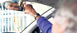 Eine Teilnehmerin des Fahrtrainings für Senioren ab 65 Jahren "Fit im Auto" stellt ihren Rückspiegel ein.