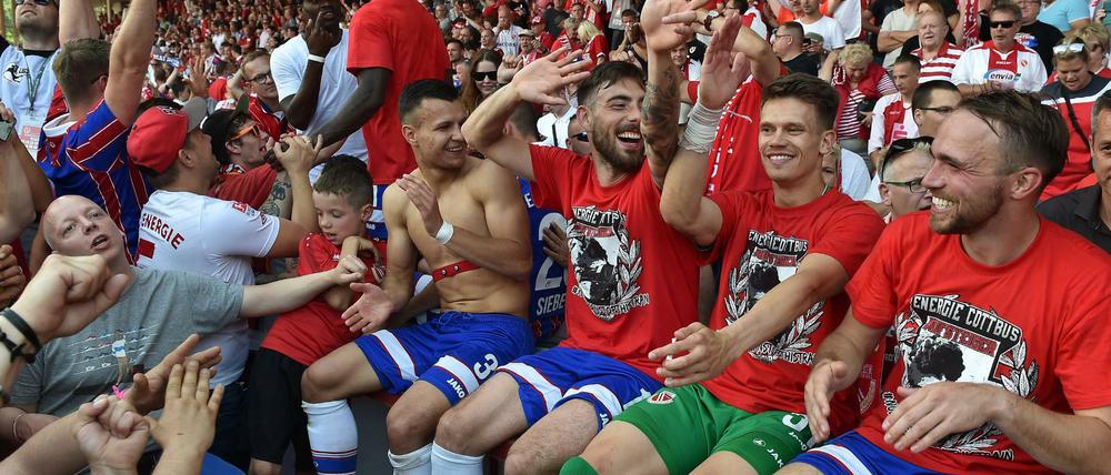 Die Cottbuser Spieler feiern nach dem 0:0 gegen Flensburg mit ihren Fans.