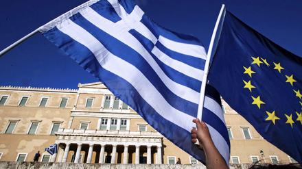 Die griechische Flagge und die EU-Fahnewerden vor dem Parlament hochgehalten. 