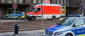 Rettungskräfte und Polizisten stehen vor dem Bahnhof in Flensburg.