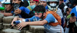 Demonstranten stehen hinter einer Barrikade in Managua.