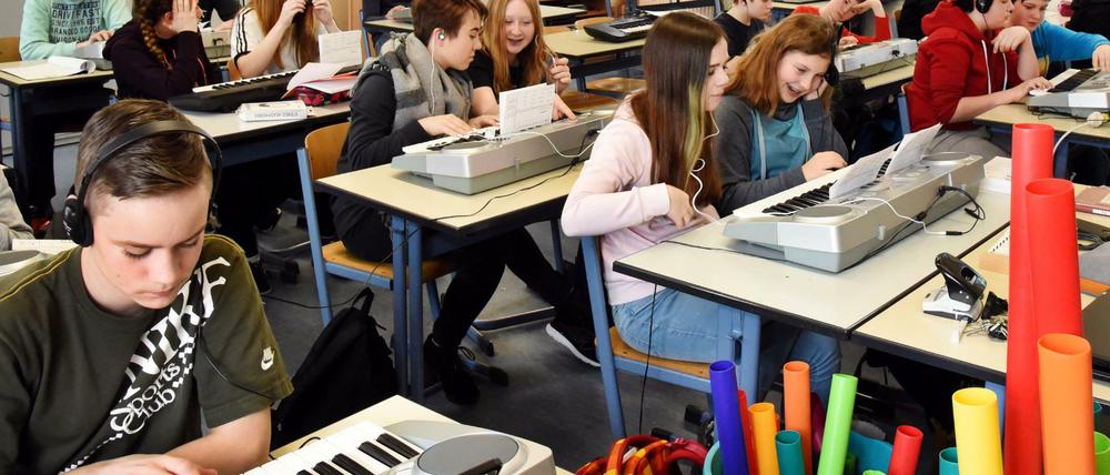 An der Oberschule in Pegau (Sachsen) üben Schülerinnen und Schüler der 7. Klasse im Musikunterricht eine Melodie am Keyboard.