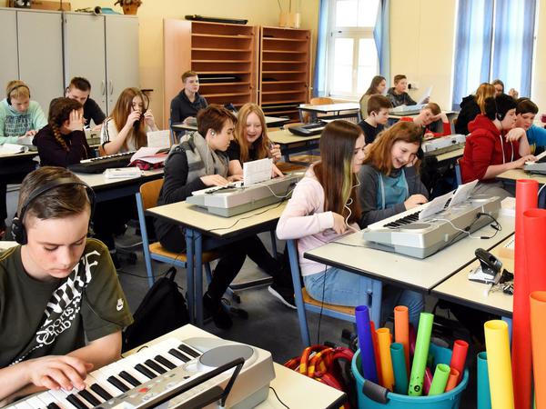 An der Oberschule in Pegau (Sachsen) üben Schülerinnen und Schüler der 7. Klasse im Musikunterricht eine Melodie am Keyboard.