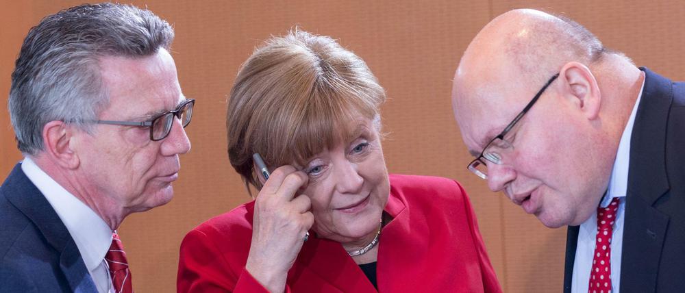 Der damalige Bundesinnenminister de Maiziere, Bundeskanzlerin Merkel und der damalige Kanzleramtsminister Altmaier (CDU)