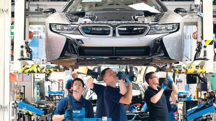 Unter der Haube. Bei Hybridmodellen wie dem BMW i8 wird – wie hier in Leipzig - noch konventionelle Verbrennungsmotortechnik verbaut. Reine E-Autos aber haben kein Getriebe, daher müssen weniger Teile hergestellt und montiert werden. Foto: Sebastian Willnow/dpa