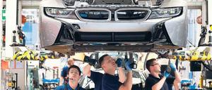 Unter der Haube. Bei Hybridmodellen wie dem BMW i8 wird – wie hier in Leipzig - noch konventionelle Verbrennungsmotortechnik verbaut. Reine E-Autos aber haben kein Getriebe, daher müssen weniger Teile hergestellt und montiert werden. Foto: Sebastian Willnow/dpa