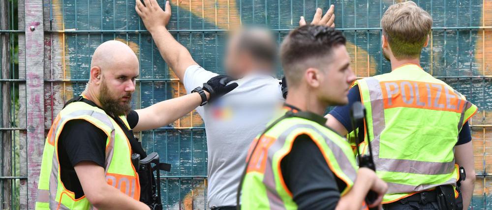 Polizisten durchsuchen am Mittwoch eine Mann an einer Berliner Grundschule in Gesundbrunnen im Bezirk Mitte. Später stellt sich heraus: falscher Alarm.