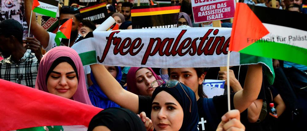 Demonstranten tragen Isreal-feindliche Banner beim jährlichen Al-Quds-Marsch in Berlin.