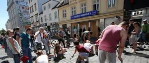 Teilnehmer eines Aufräumaktion putzen im Juli 2017 das Schulterblatt im Schanzenviertel in Hamburg. Im Hintergrund ist die Filiale der Drogeriekette Budnikowsky zu sehen, die in der Nacht zum 8. Juli geplündert und verwüstet wurde.