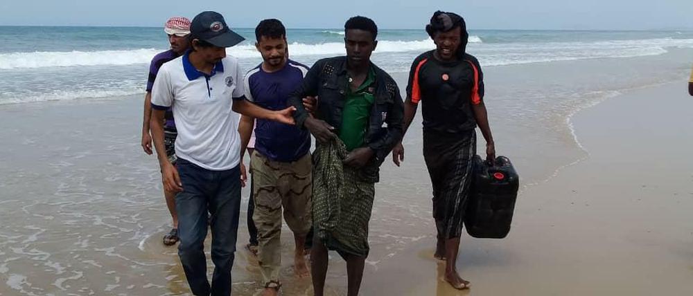 Mitarbeiter der Internationalen Organisation für Migration aus dem Jemen helfen einem Überlebenden des Bootsunglücks.