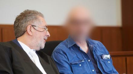Der Angeklagte sitzt auf der Anklagebank des Landgerichts neben seinem Verteidiger Michael Aßhauer (l).