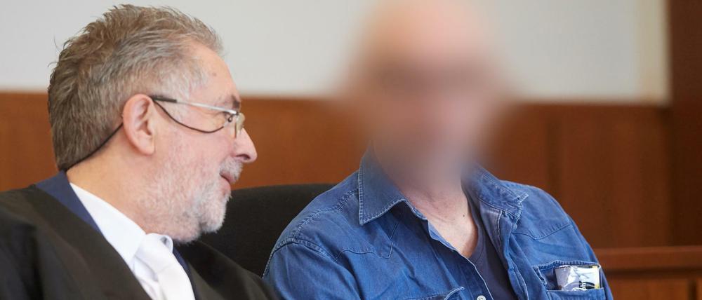 Der Angeklagte sitzt auf der Anklagebank des Landgerichts neben seinem Verteidiger Michael Aßhauer (l).
