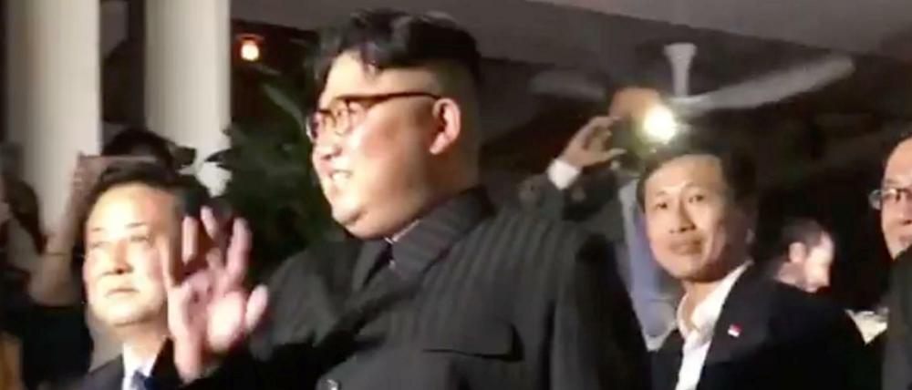 Nordkoreas Machthaber Kim Jong Un winkt in Singapur Fotografen zu. 