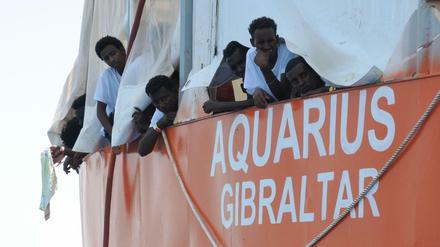 Aus Seenot gerettete Migranten blicken von dem Rettungsschiff "Aquarius" herunter.