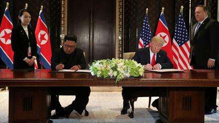 Nordkoreas Machthaber Kim Jong Un und US-Präsident Donald Trump unterzeichnen gemeinsam ein Dokument.