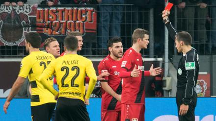 Schiedsrichtern zeigt man besser keine Zeitlupen von Fouls. Sie entscheiden dann unbewusst meist härter als ohne das technische Hilfsmittel. Am 14. Spieltag der vergangenen Bundesliga-Saison zeigte Referee Robert Hartmann Leverkusens Wendell (l.) die rote Karte, nachdem er sich den Videobeweis angesehen hatte.