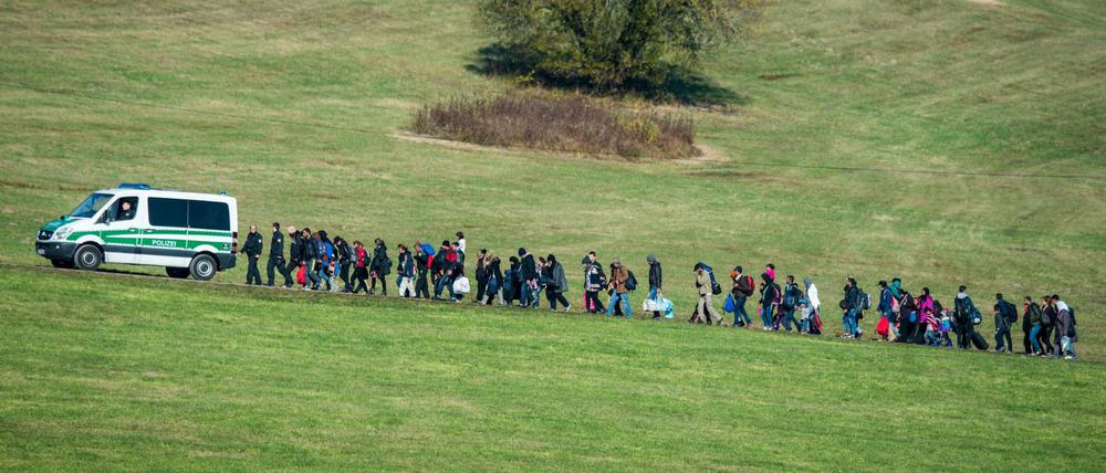 Auf dem Höhepunkt der Krise: Flüchtlinge gehen im Oktober 2015 hinter einem Fahrzeug der Bundespolizei.