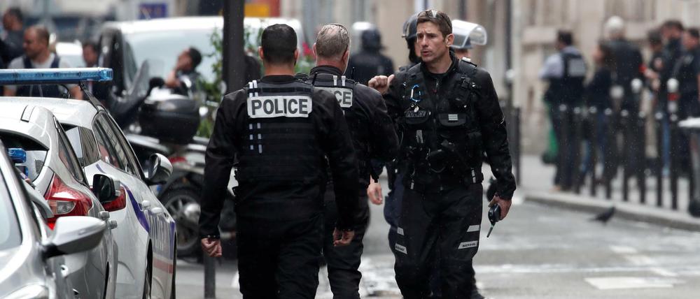 Französische Polizisten sichern die Straße, in der ein Mann mehrere Menschen als Geisel genommen hat.