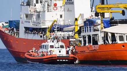Ein Schiff der italienischen Küstenwache legt am Rettungsschiff Aquarius an.