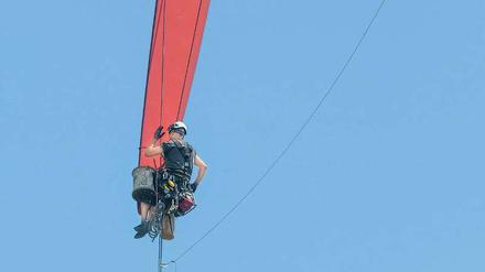 Ein Fachmann inspiziert in Brandenburg die Rotorspitze einer Windkraftanlage. 