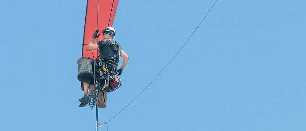Ein Fachmann inspiziert in Brandenburg die Rotorspitze einer Windkraftanlage.