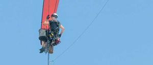 Ein Fachmann inspiziert in Brandenburg die Rotorspitze einer Windkraftanlage. 