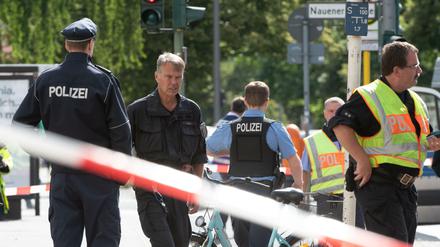 Polizisten stehen in Spandau an der Kreuzung Nauener Straße/Brunsbütteler Damm.