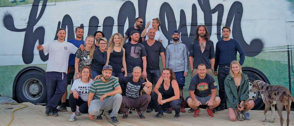 Street-Art-Kultur auf dem Riesenrad-Areal: Künstler von „Wandelism“ vor einem Bus mit ihrem Motto „The Spirit of hometown“.