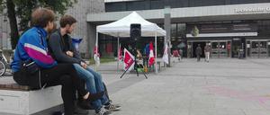 Streikposten und müde Besetzer*innen sitzen vor dem Hauptgebäude der TU Berlin.