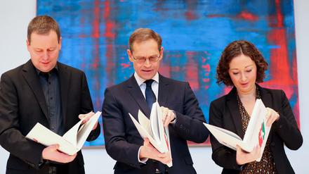 Die rot-rot-grünen Koalitionäre werfen einen Blick in den Koalitionsvertrag.