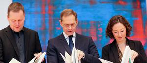 Die rot-rot-grünen Koalitionäre werfen einen Blick in den Koalitionsvertrag.