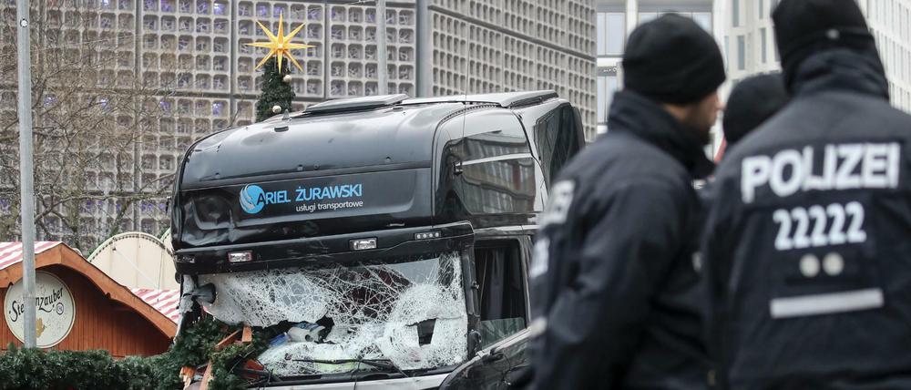 Polizisten stehen vor dem zerstörten Lkw am Weihnachtsmarkt am Breitscheidplatz in Berlin.