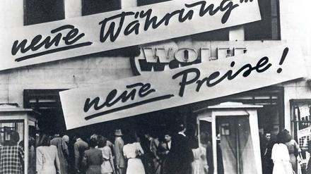 Werbung für "neue Währung ... neue Preise" an einem westdeutschen Geschäft zur Zeit der Währungsreform von 1948.
