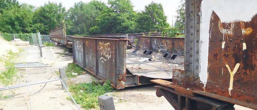 Seit zweieinhalb Jahren liegen die denkmalgeschützten Brücken ungeschützt im Gleisdreieckpark. Der Zaun um sie herum ist teilweise umgestoßen.
