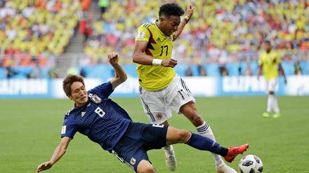 Mit harten Bandagen. Genki Haraguchi (l) aus Japan kämpft mit Johan Mojica aus Kolumbien um den Ball. 