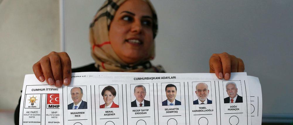 Eine Wahlhelferin hält einen Stimmzettel, auf dem die Kandidaten für die Präsidentenwahl aufgelistet sind.