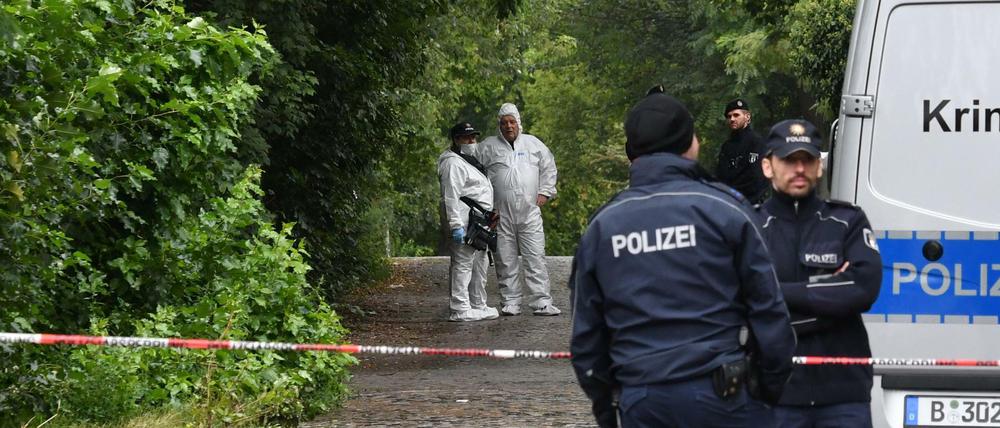 Einsatzkräfte der Polizei und Kriminaltechniker in Berlin an einem Weg am Hardenbergplatz.
