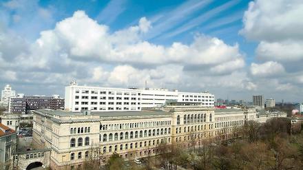 Das Hauptgebäude der Technischen Universität Berlin unter wolkenverhangenem Himmel.