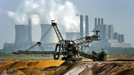 Ein Bagger fährt vor der Kulisse des RWE-Kraftwerkes Niederaußem durch den Tagebau Garzweiler. 