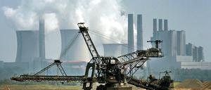 Ein Bagger fährt vor der Kulisse des RWE-Kraftwerkes Niederaußem durch den Tagebau Garzweiler. 