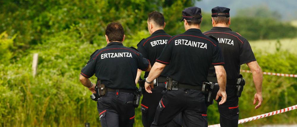 Spanische Polizisten steigen am Fundort einer Frauenleiche, nahe der Autobahn bei Asparrena, über eine Absperrung.