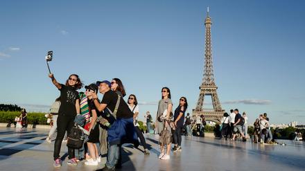 Wir und die Welt. Touristinnen vor dem Pariser Eiffelturm.