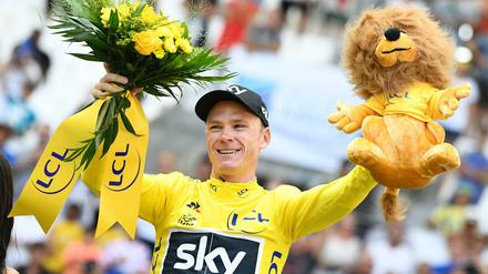 Der Brite Christopher Froome jubelt auf dem Podium im Gelben Trikot des Gesamtführenden. 