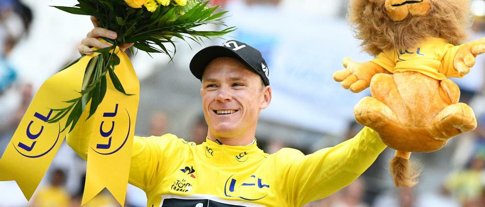 Der Brite Christopher Froome jubelt auf dem Podium im Gelben Trikot des Gesamtführenden.
