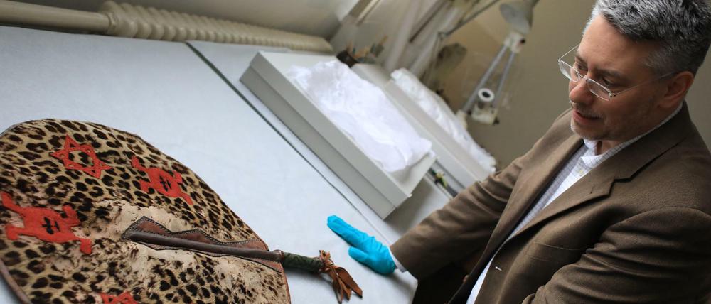 Wo kommt es her, wem gehört es und wie kam es hierhin? Kurator Jonathan Fine von der Provenienzforschung des Humboldt-Forums mit einem Fächer aus Benin.  