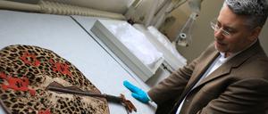 Wo kommt es her, wem gehört es und wie kam es hierhin? Kurator Jonathan Fine von der Provenienzforschung des Humboldt-Forums mit einem Fächer aus Benin.  