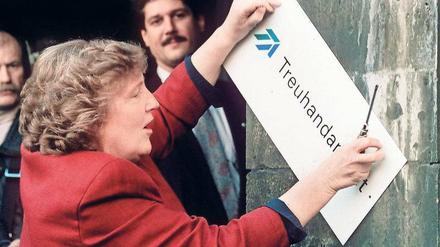 Weg damit. Die scheidende Treuhand-Präsidentin Birgit Breuel entfernt am 30. Dezember 1994 mit einem Schraubenzieher das Firmenschild am Eingang der Treuhandanstalt in Berlin-Mitte, dem heutigen Sitz des Bundesfinanzministeriums. 