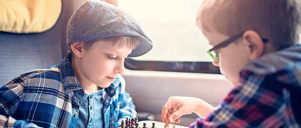 Du bist dran. Brettspiele vertreiben vor allem größeren Kindern die Langeweile bei Bahnfahrten besonders gut.