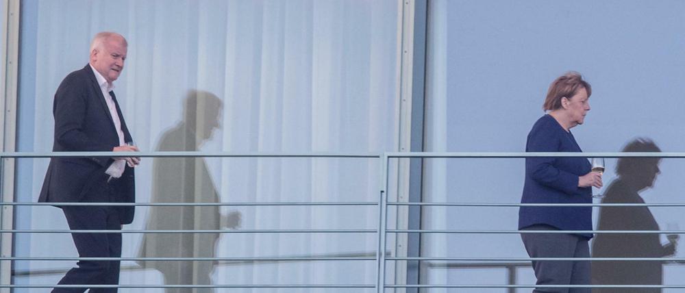 Bundeskanzlerin Angela Merkel (r, CDU) geht auf einem Balkon des Bundeskanzleramts vor Horst Seehofer, Bundesminister für Inneres, Heimat und Bau.