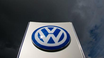 Dunkle Wolken ziehen über ein VW-Logo am Tor Sandkamp vom VW Werk in Wolfsburg hinweg.